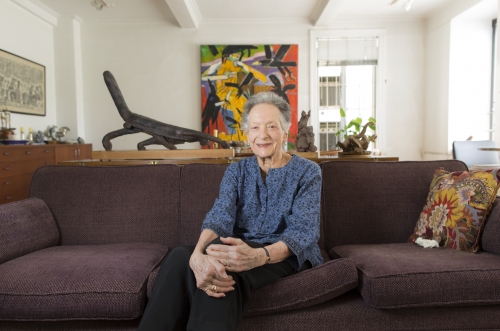 a retired judge sits on her couch in front of a painting